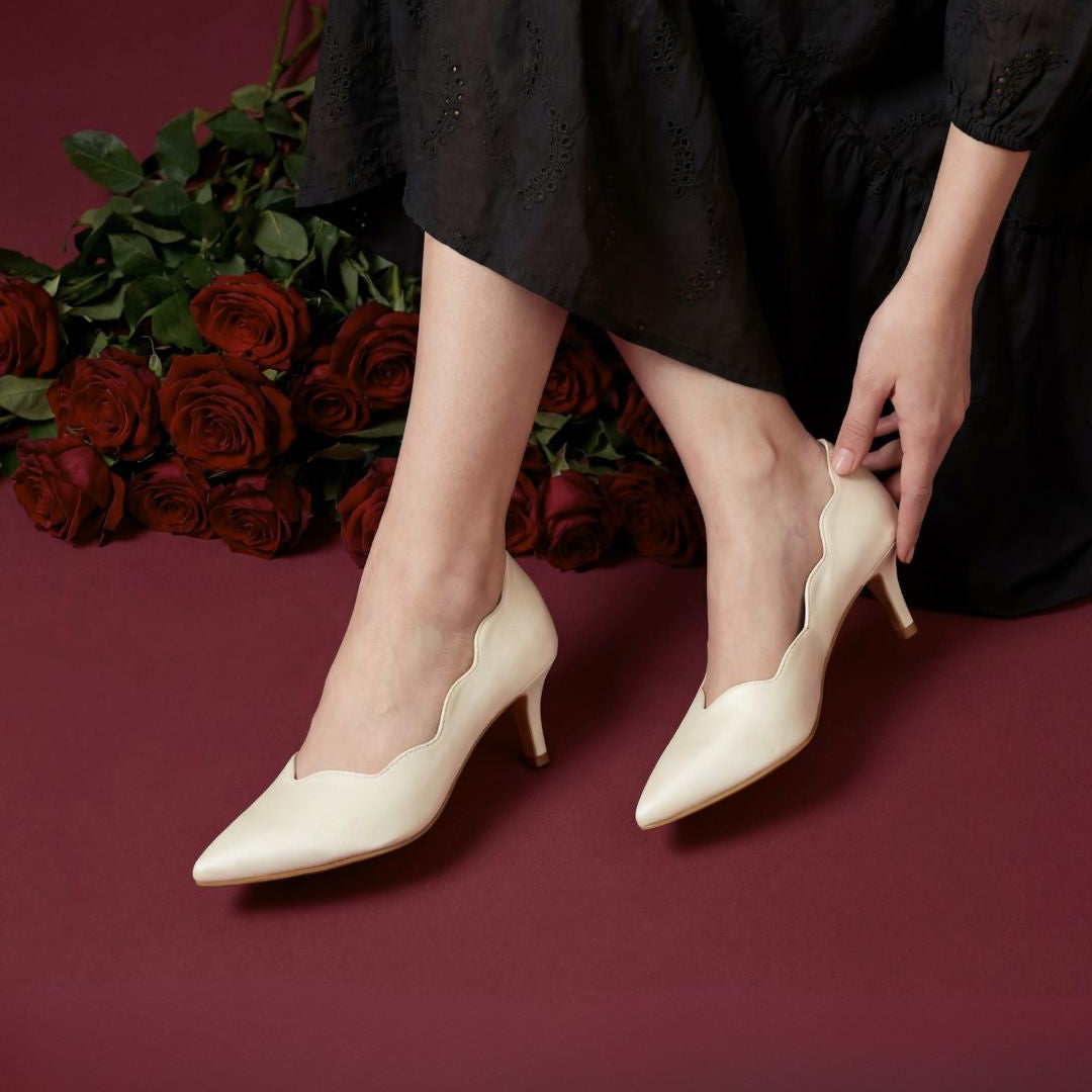 Person wearing white high-heeled shoes on a red background with roses.